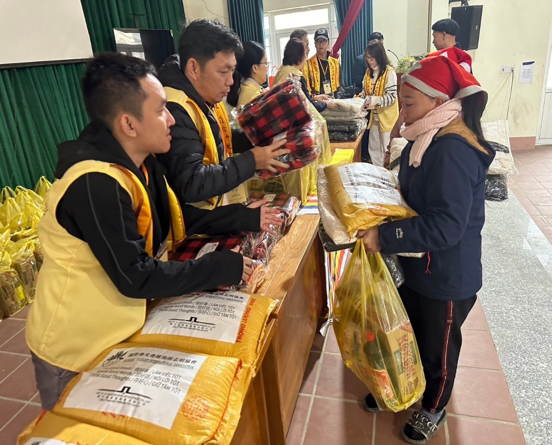 A group of people in a room with bags of food

Description automatically generated