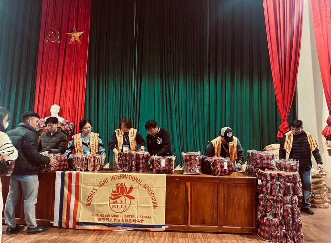 A group of people sitting at a table with boxes on it

Description automatically generated