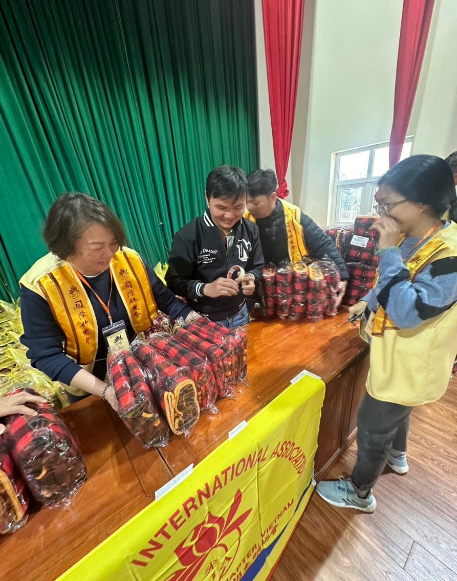 A group of people standing at a table with bags of food

Description automatically generated