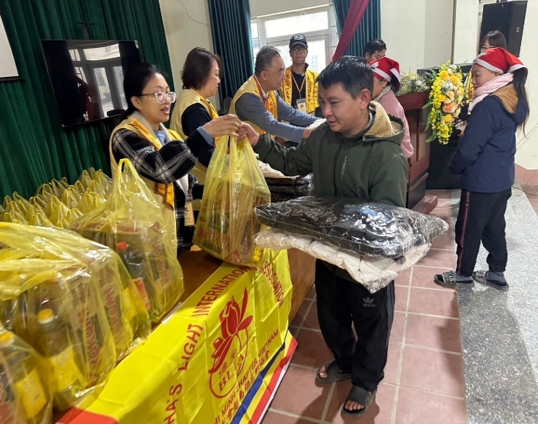 A group of people standing next to a table with bags of food

Description automatically generated