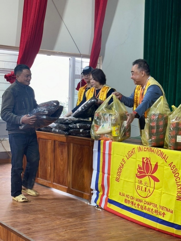 A group of people standing next to a table with bags of food

Description automatically generated
