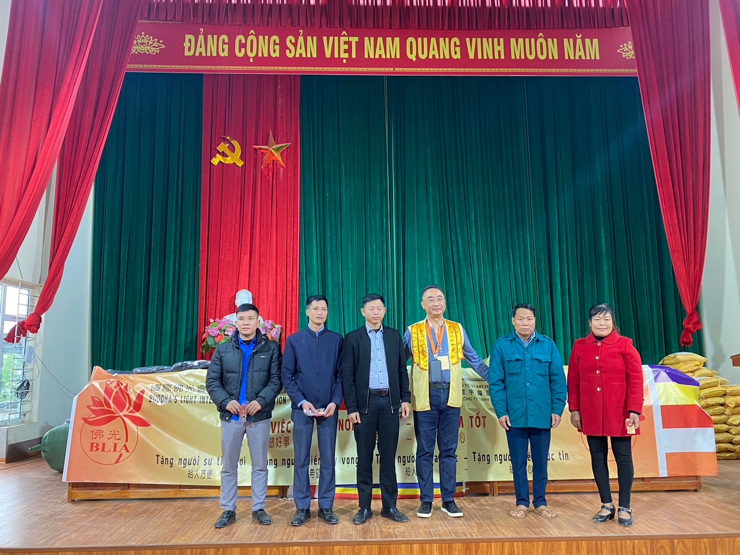A group of people standing on a stage

Description automatically generated