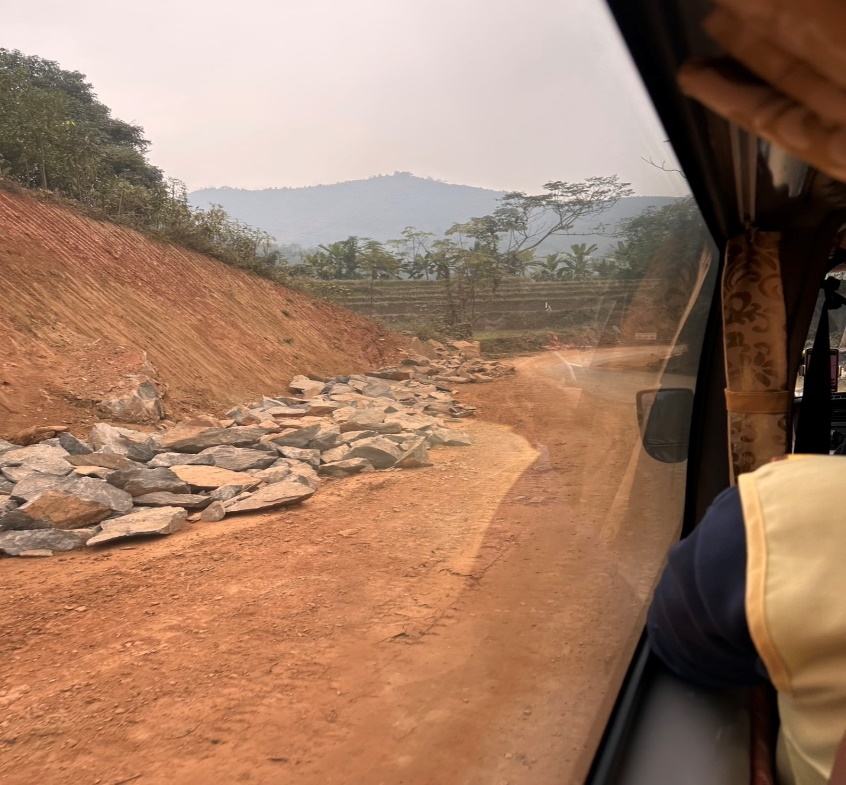 A view from a car of a road with rocks and dirt

Description automatically generated